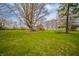 A well-maintained lawn and a single-story home nestled under the shade of mature trees at 1911 N Rangeline Rd, Anderson, IN 46012