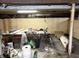Unfinished basement featuring low ceilings, exposed beams, and a workbench with assorted tools and equipment at 2208 Avondale Pl, Indianapolis, IN 46218