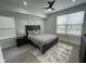 Modern bedroom features a ceiling fan, a stylish rug, and a dark bed frame with luxurious pillows at 2232 Central Ave, Indianapolis, IN 46205