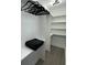 Bright walk-in closet with built-in shelving, a hanging rod, and modern vinyl flooring, offering ample storage space at 2232 Central Ave, Indianapolis, IN 46205