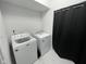 Clean laundry room features a new washer and dryer, tile floor, and black curtain at 2232 Central Ave, Indianapolis, IN 46205