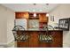 A modern bar area includes updated cabinets, granite counters, and bar stools at 2507 Silver Oaks Dr, Carmel, IN 46032