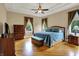 A primary bedroom with tray ceilings, crown moulding and warm hardwood floors and ensuite bath at 2507 Silver Oaks Dr, Carmel, IN 46032