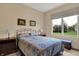 Comfortable bedroom with a bright window offering lovely views of the green, landscaped surroundings at 2507 Silver Oaks Dr, Carmel, IN 46032