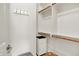 Organized walk-in closet with wooden hanging rods, white shelving, and a compact storage cabinet at 2507 Silver Oaks Dr, Carmel, IN 46032