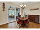 Dining area with a wooden table set with red cushions and views of the sunroom at 2507 Silver Oaks Dr, Carmel, IN 46032