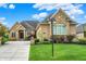 Charming brick home with a manicured lawn and a well-maintained driveway with beautiful blue skies above at 2507 Silver Oaks Dr, Carmel, IN 46032