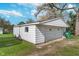 Exterior view of a detached garage with white siding, a gable roof, and a green garbage receptacle at 2735 S Taft Ave, Indianapolis, IN 46241
