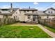 Backyard of a two-story home with a small deck, brick pathway, and green grass at 2926 Indianapolis Ave, Indianapolis, IN 46208