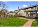 Backyard of a two-story home with a small deck, brick pathway, and green grass at 2926 Indianapolis Ave, Indianapolis, IN 46208
