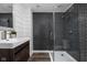 Modern bathroom featuring a glass-enclosed shower, dark tile, and sleek vanity at 310 W 43Rd St, Indianapolis, IN 46208