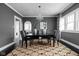 Elegant dining room featuring a modern chandelier, dark wood floors, and gray walls with white trim at 310 W 43Rd St, Indianapolis, IN 46208