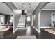 Elegant foyer with dark hardwood floors, a staircase, arched doorways, and neutral gray walls at 310 W 43Rd St, Indianapolis, IN 46208