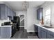 This spacious kitchen boasts stylish blue cabinets, stainless steel appliances, and wood flooring at 310 W 43Rd St, Indianapolis, IN 46208