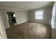 Cozy living room with neutral carpeting and a view into the kitchen area at 3202 Acacia Dr, Indianapolis, IN 46214