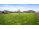 Expansive backyard featuring lush green lawn, privacy fence, and mature trees, perfect for outdoor enjoyment at 3300 E Indian Hill Dr, Muncie, IN 47302