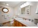 Bright bathroom with marble countertop vanity, toilet, and built-in lighting at 3300 E Indian Hill Dr, Muncie, IN 47302