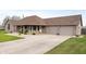 Lovely brick home with an attached three car garage and an expansive driveway and well-kept lawn at 3300 E Indian Hill Dr, Muncie, IN 47302