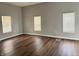 A bright living room features beautiful wood floors and three large windows at 3502 N Illinois St, Indianapolis, IN 46208