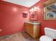 Bathroom with a single vanity, mirror, and a toilet to the right of the vanity and the brown tiled floors at 3504 Morgan Oaks Cir, Martinsville, IN 46151