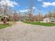 View of a gravel driveway leading to a house and outbuildings surrounded by trees and grass at 3504 Morgan Oaks Cir, Martinsville, IN 46151