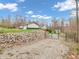 Long gravel driveway to home with a detached garage and wooded area behind a rock wall at 3504 Morgan Oaks Cir, Martinsville, IN 46151