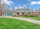 Charming single-story home with green roof, lush lawn, a two car garage and a gravel driveway at 3504 Morgan Oaks Cir, Martinsville, IN 46151
