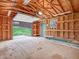 Partially open garage with plywood walls, shelves, and a view to the yard, offering storage and utility at 3504 Morgan Oaks Cir, Martinsville, IN 46151