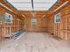 Bright, unfinished garage with plywood walls, windows, and shelves, perfect for storage or workshop at 3504 Morgan Oaks Cir, Martinsville, IN 46151