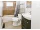 Functional bathroom featuring a bathtub with tile surround, toilet, a sleek sink, and a metal shelving unit at 3550 Winings Ave, Indianapolis, IN 46221