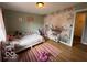 Charming bedroom with hardwood floors, decorated with a playful dinosaur themed wall with natural light at 3689 S County Road 800 W, Coatesville, IN 46121