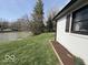 Side view of the home with landscaping and a pond in the background at 3689 S County Road 800 W, Coatesville, IN 46121