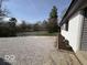 White brick home with gravel drive, partial lake view, and small flower garden at 3689 S County Road 800 W, Coatesville, IN 46121