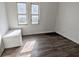 Bright bedroom featuring two windows, wood-look floors, and storage bench at 408 E Beecher St, Indianapolis, IN 46225