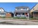Charming two-story home with a gray roof and small front yard with chain link fence at 408 E Beecher St, Indianapolis, IN 46225