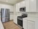 Modern kitchen featuring white cabinets and stainless steel appliances including a range and refrigerator at 4087 Railhead Ave, Westfield, IN 46074