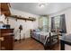 Comfortable bedroom with hardwood floors, a metal frame bed, shelves and a vintage green wardrobe at 409 W Pike St, Martinsville, IN 46151