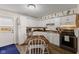 Cozy kitchen with white cabinets, stainless steel appliances, and a rustic dining table at 409 W Pike St, Martinsville, IN 46151