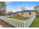 Spacious backyard with a wooden deck, well-maintained lawn, and traditional white picket fence at 409 W Pike St, Martinsville, IN 46151