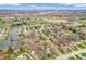 An aerial view showcases a suburban neighborhood with lush greenery, a pond, and winding streets under a blue sky at 454 Roberson Blvd, Mooresville, IN 46158