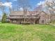Brick home with a large deck, walkout basement, manicured lawn, mature trees, and brick chimney at 454 Roberson Blvd, Mooresville, IN 46158