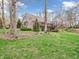 Beautiful backyard featuring a lush lawn, mature trees, and a charming brick home with a spacious deck at 454 Roberson Blvd, Mooresville, IN 46158