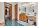 Bathroom featuring double sinks, wood cabinets, a walk-in closet, and green tile flooring at 454 Roberson Blvd, Mooresville, IN 46158