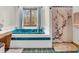 Bright bathroom featuring a teal soaking tub under a window and a decorative shower curtain with artistic floral design at 454 Roberson Blvd, Mooresville, IN 46158