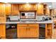 Kitchen with wooden cabinets, dishwasher, and a pass-through overlooking the living room at 454 Roberson Blvd, Mooresville, IN 46158