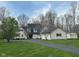 Traditional home showcasing a long driveway, lush lawn, and gray siding, complemented by dark shutters and a black roof at 4560 S 975 E, Zionsville, IN 46077