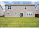 The back of the home featuring a sliding glass door, windows, and a grass lawn at 5374 Marigold Dr, Plainfield, IN 46168