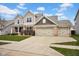 Charming two-story home boasts a three-car garage, beautiful brick accents and manicured lawn at 5374 Marigold Dr, Plainfield, IN 46168