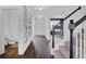 Bright hallway with wood flooring, stairwell, and unique artwork, leading to various rooms at 5374 Marigold Dr, Plainfield, IN 46168