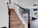 Carpeted staircase with dark wood banister and white risers leading to a living area at 5374 Marigold Dr, Plainfield, IN 46168